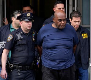 New York City Police and law enforcement officials lead subway shooting suspect Frank James, center, away from a police station in New York on April 13, 2022.