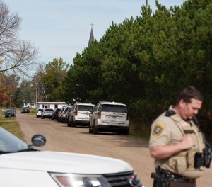 A Benton County sheriff establishes a security perimeter at the intersection of 186th Avenue NE and Glendorado Road NE near Princeton, Minn., following a 