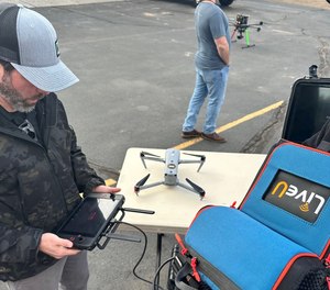 An attendeee at the Law Enforcement Drone Association's 2023 annual conference prepares to stream video from a drone using LiveU technology.