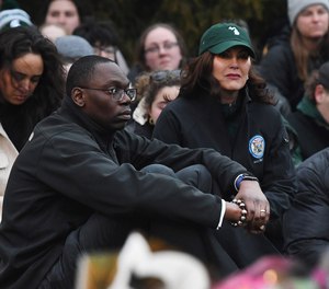 Michigan Lt. Gov. Garlin Gilchrist II, left, and Gov. Gretchen Whitmer sit at the memorial after laying down flowers at a Michigan State University vigil to honor and remember the student victims involved in a campus shooting on Feb. 13, in East Lansing, Michigan, on Feb. 15, 2023.