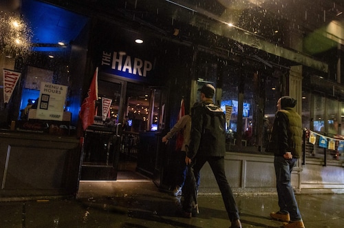 Men walk into the Harp, a popular sports bar near Boston's TD Garden. This was the tavern where prosecutors say two victims of sexual assault encountered Campbell in 2017. Campbell allegedly posed as a bouncer there and offered them a ride. Another woman accused Campbell of raping her after giving her a ride from the same bar two years later. (Jesse Costa/WBUR)