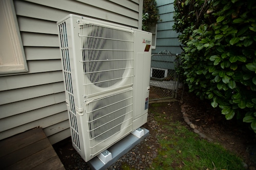 A heat pump compressor next to a house