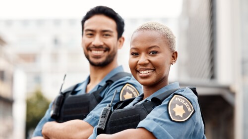 Happy police, team and arms crossed in confidence for city protection, law enforcement or crime. Portrait of man and woman officer standing ready for justice, security or teamwork in an urban town