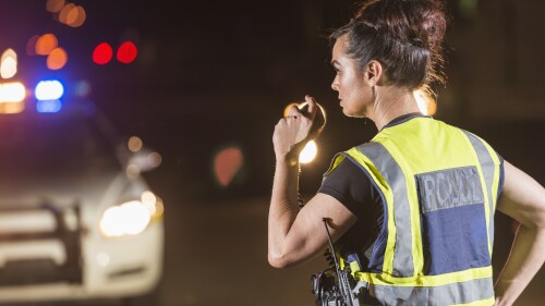 Female police officer at night, talking on radio