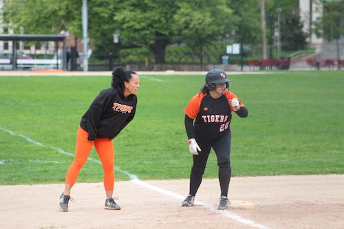 Newton North coach Lauren Baugher talking to freshman Ashlyn Baugher who stands on third base.