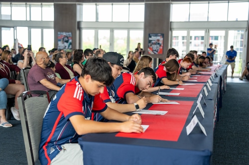 Athletes and their partners sign their deals to play for the New England Revolution Unified Soccer Team.