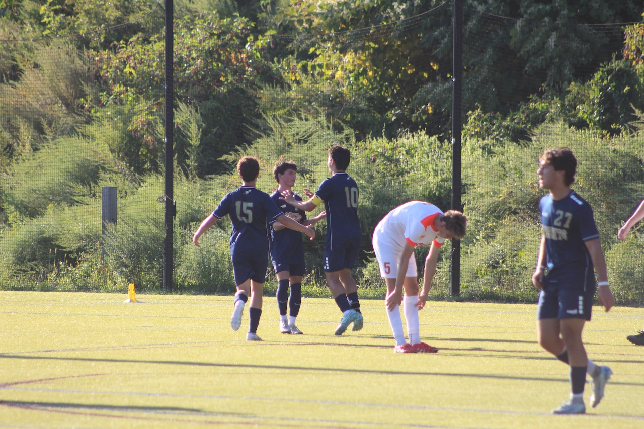 Avery Brodsky (10) and Zack Leibman (7) celebrate Brodsky's goal for Needham boys soccer against Newton North.