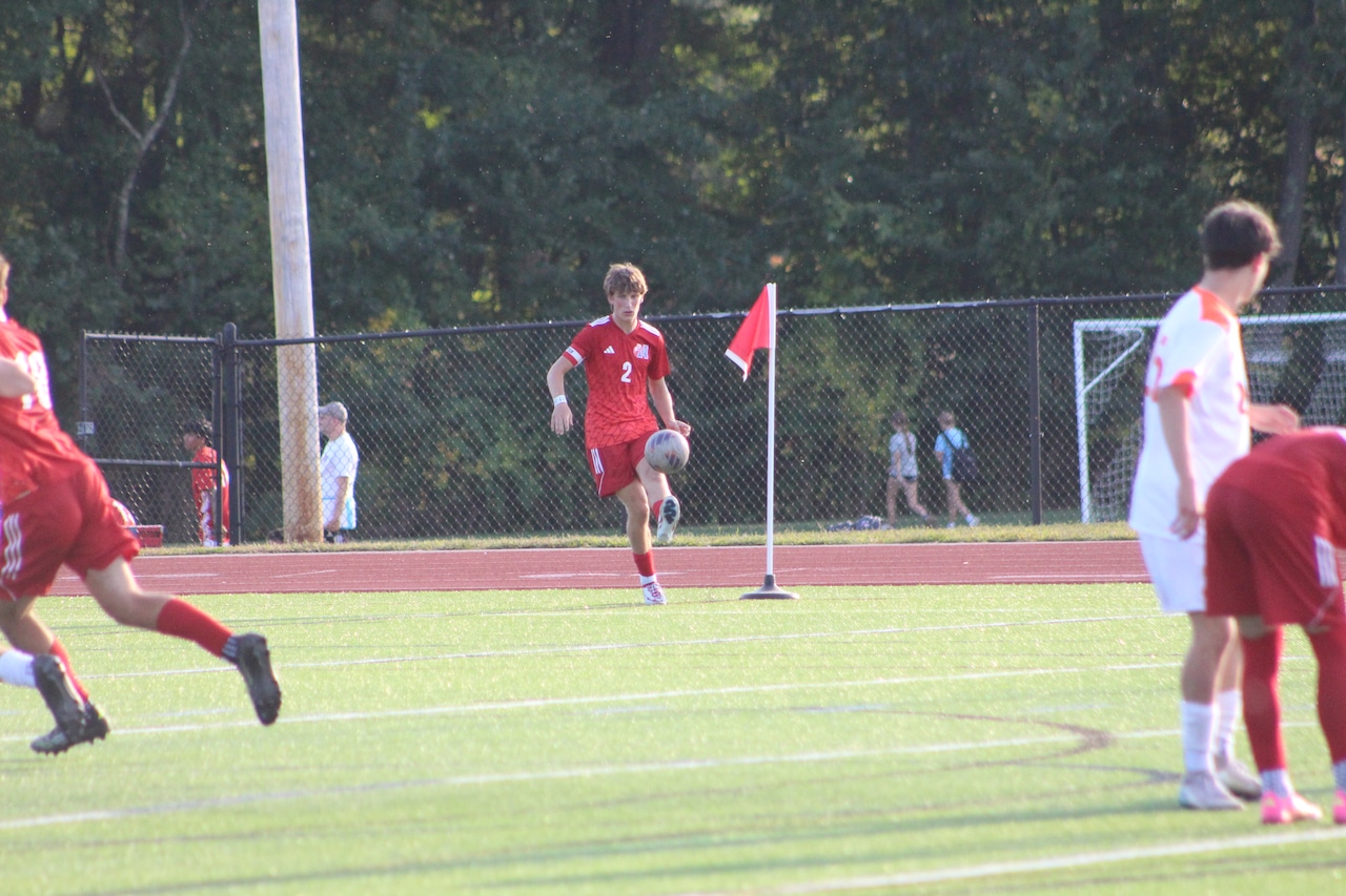 Luke Dougherty takes a corner kick for Natick boys soccer against Newton North.