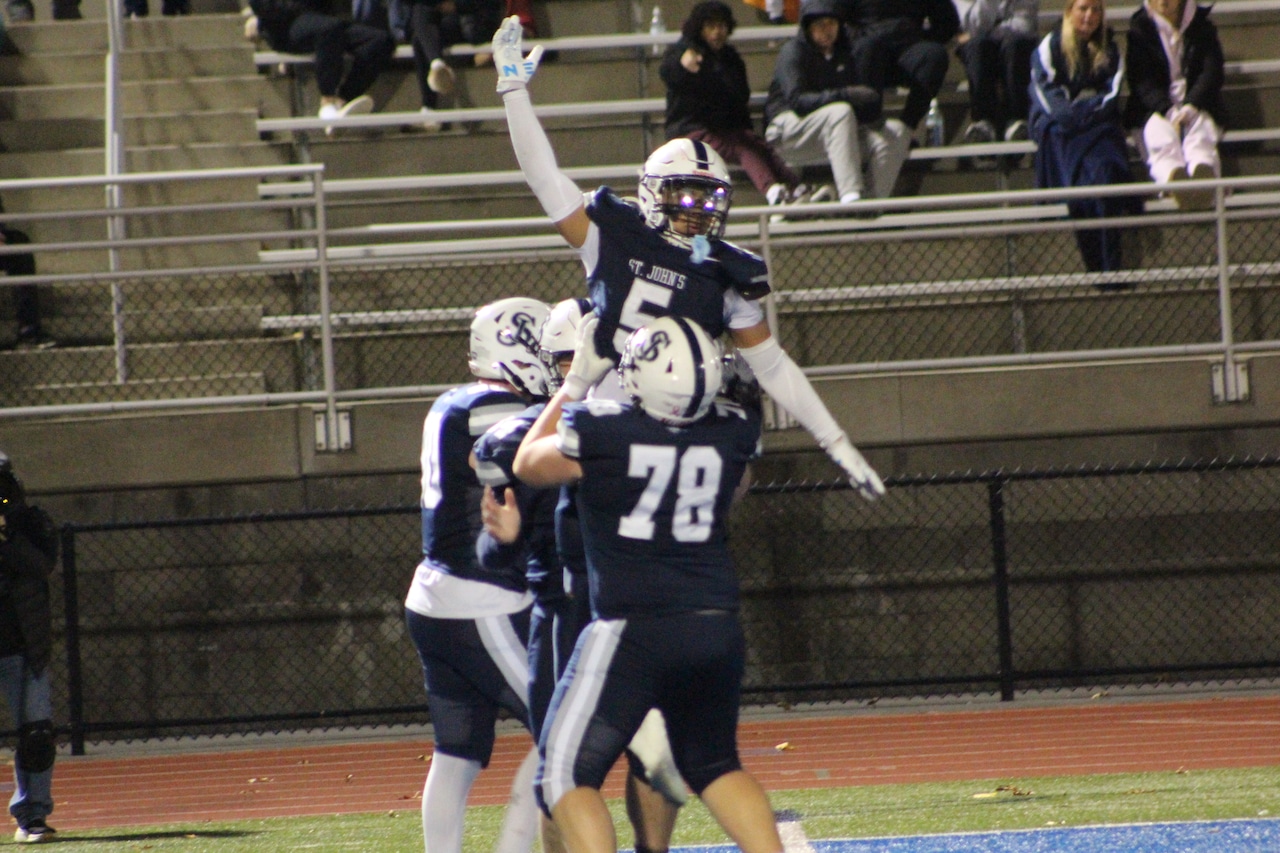 Will Figulski lifts Maxwell Parent after Parents fifth touchdown of the game for St. John's Prep against Leominster.