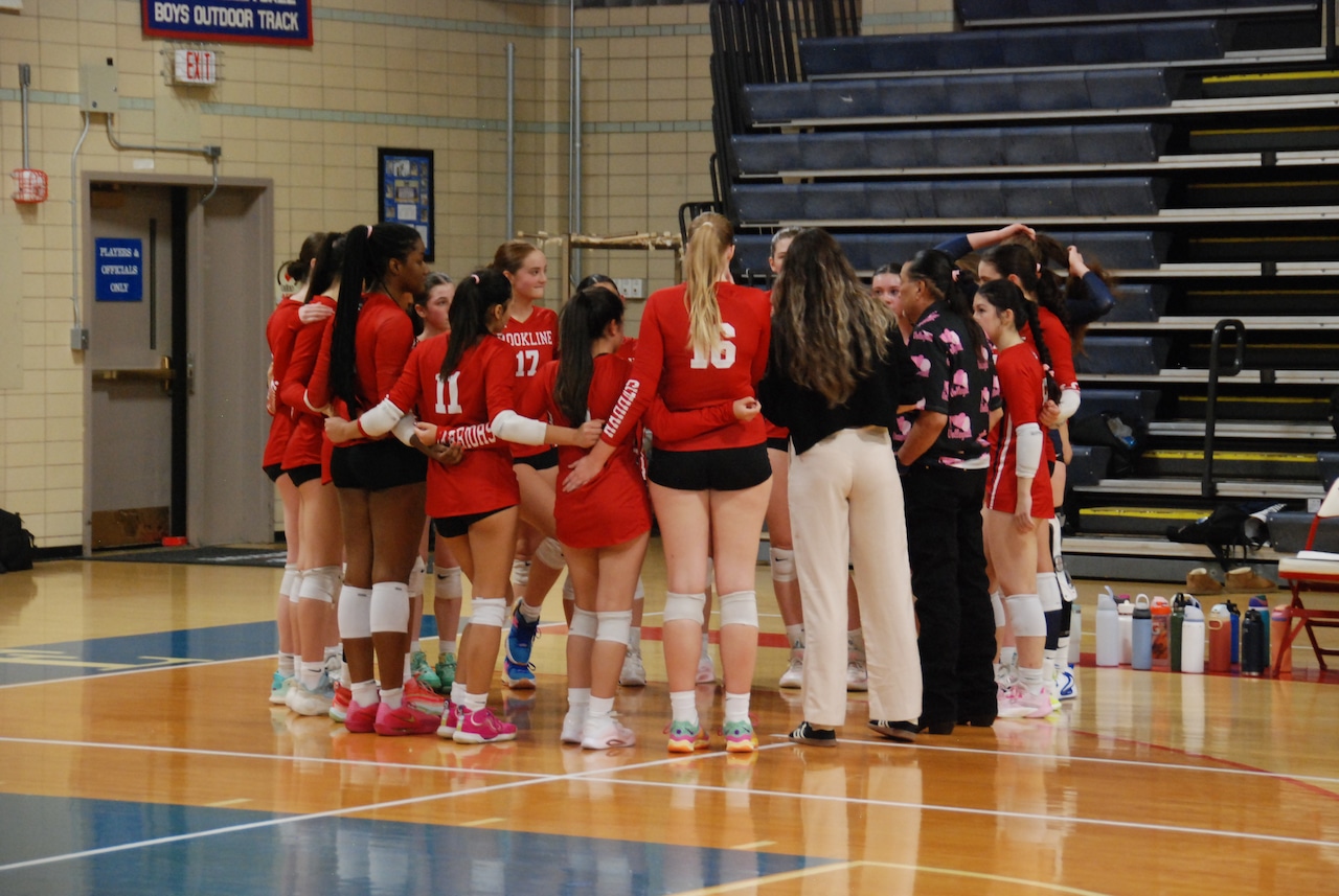 The Brookline Warriors huddle during a timeout early in their match against the Attleboro Bombardiers.