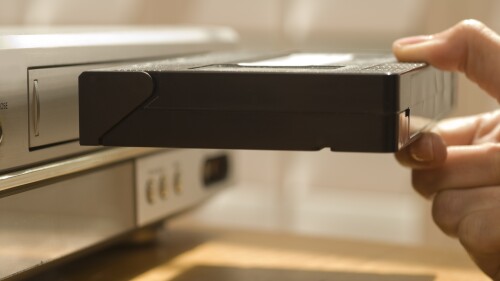 Hand putting VHS tape in a VCR