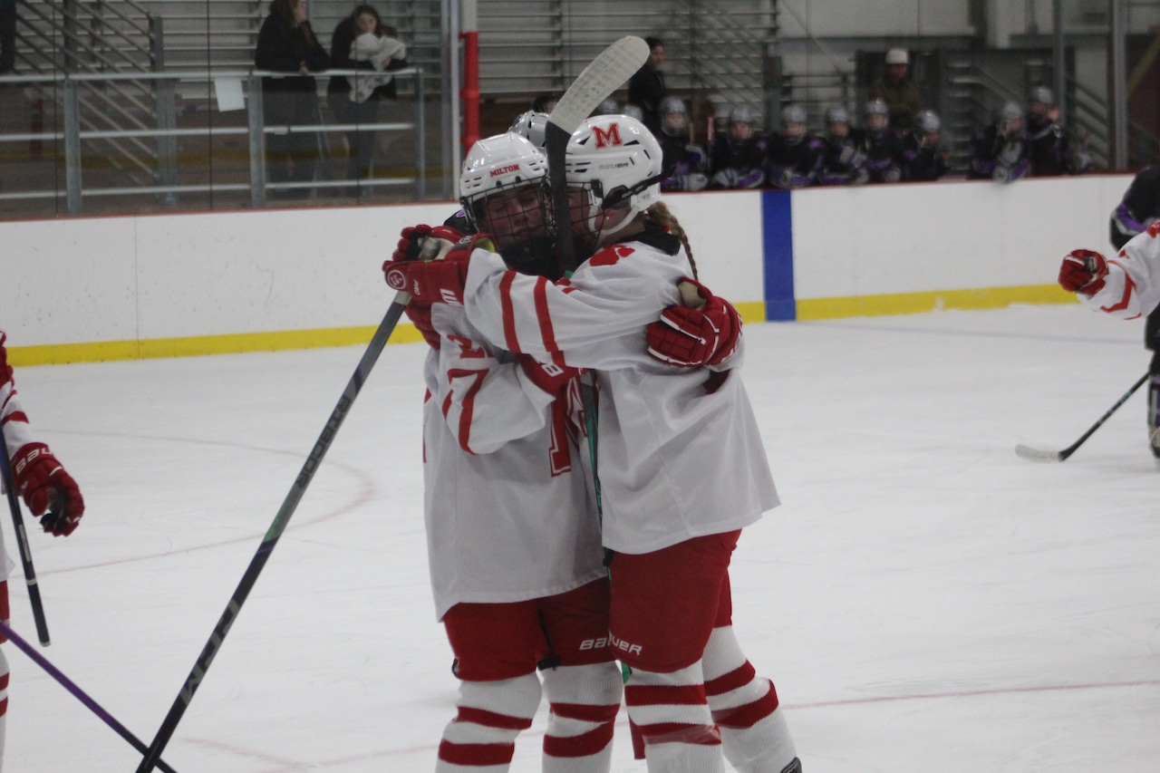 Nayeli Thayer hugs Mia Cataruzolo after she scored for Milton girls hockey.